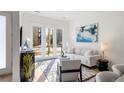 Bright living room featuring a white sofa, modern art, and natural light streaming through glass doors at 1735 E 18Th Ave, Denver, CO 80218