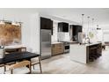 Modern kitchen featuring an island with seating, stainless steel appliances, and light hardwood floors at 4481 Raleigh St, Denver, CO 80211