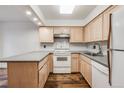 Well-equipped kitchen with light wood cabinets and gray countertops at 1050 S Monaco Pkwy # 77, Denver, CO 80224