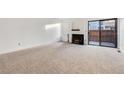 Spacious living room featuring a fireplace and neutral carpeting at 1050 S Monaco Pkwy # 77, Denver, CO 80224