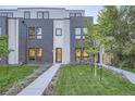 Contemporary townhome with gray brick exterior, walkway, and manicured lawn at 2947 S Elati St, Englewood, CO 80110