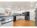 Spacious kitchen featuring modern stainless steel appliances and custom white cabinetry at 14032 E Chenango Dr, Aurora, CO 80015