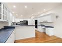 Bright kitchen with white cabinets, granite countertops, and hardwood floors at 14032 E Chenango Dr, Aurora, CO 80015
