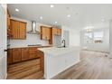 Bright, open kitchen with stainless steel appliances, large island, and wood-look floors at 3431 N Denali St, Aurora, CO 80019