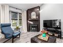 Cozy living room features a fireplace, a comfortable chair, and large window at 3082 W 107Th Pl # H, Westminster, CO 80031