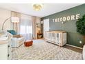 Bedroom featuring white crib, chair, shag carpet and decorative wall decor at 3532 Springbriar Dr, Castle Rock, CO 80109