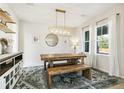 Dining room featuring a rustic wooden table and bench with a modern chandelier at 3532 Springbriar Dr, Castle Rock, CO 80109