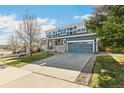 Inviting blue two-story home with stone accents, a covered porch, and a convenient two-car garage at 3532 Springbriar Dr, Castle Rock, CO 80109