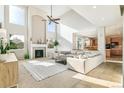 Bright living room featuring a fireplace, high ceilings, and an open floor plan leading to the kitchen at 3532 Springbriar Dr, Castle Rock, CO 80109