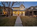 Inviting two-story home featuring a covered porch, white siding, metal roof and manicured lawn at 652 S Race St, Denver, CO 80209