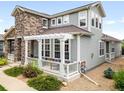 Charming home with stone accents, a covered porch, and manicured landscaping at 5723 S Union Ct, Littleton, CO 80127