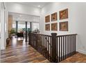 Bright open hallway with hardwood floors, decorated with wood art, overlooks the living room at 14582 Mission Walk Loop, Parker, CO 80134