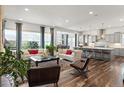 Open-concept design living room flows into the modern kitchen with island and dining area at 14582 Mission Walk Loop, Parker, CO 80134