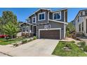 Attractive two-story home featuring a brown garage door, stone accents, and landscaped front yard at 10694 Cedarcrest Cir, Highlands Ranch, CO 80130