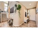 Bright foyer featuring hardwood floors, staircase, coat rack and tasteful decor at 10694 Cedarcrest Cir, Highlands Ranch, CO 80130