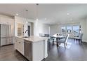 Open-concept kitchen, dining, and living space with stainless steel appliances and modern finishes and lots of natural light at 3961 Happy Hollow Dr, Castle Rock, CO 80104