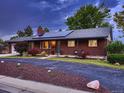 A charming brick home with solar panels, well-maintained landscaping, and a paved driveway at 7112 S Platte Canyon Dr, Littleton, CO 80128