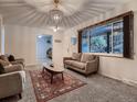 Bright living room featuring a large window, comfortable seating, and a decorative rug at 7112 S Platte Canyon Dr, Littleton, CO 80128