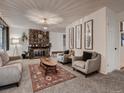 Cozy living room with a stone fireplace, chandelier, and stylish furniture at 7112 S Platte Canyon Dr, Littleton, CO 80128