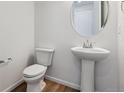 Modern half-bathroom with a pedestal sink, updated fixtures, and stylish decor at 9652 Cathay St, Commerce City, CO 80022