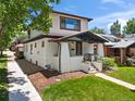 Two-story home with a covered front porch, white brick accents, tidy landscaping, and a well-maintained lawn at 400 S Gilpin St, Denver, CO 80209
