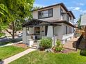 Two-story home featuring a covered porch, neat landscaping, and a well-manicured lawn on a sunny day at 400 S Gilpin St, Denver, CO 80209