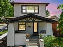 Inviting home boasting a covered porch with black accents, white brick pillars, and colorful potted flowers at 400 S Gilpin St, Denver, CO 80209