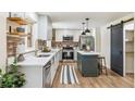 Beautiful kitchen with stainless steel appliances, white cabinets, and a cozy island with seating at 1155 W 4Th Ave, Broomfield, CO 80020