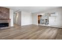 Open-concept living room leads to dining area with view of brick fireplace at 1021 Carr St # 37, Lakewood, CO 80214