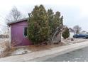 Side view of the home with mature trees and a detached garage, providing extra parking or storage at 634 S Hazel Ct, Denver, CO 80219