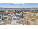 An aerial view showcasing the house surrounded by beautiful scenery and a well-kept landscape at 555 Coal Bank Trl, Castle Rock, CO 80104
