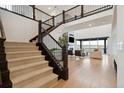 The light foyer features hardwood floors, a grand staircase with an open-concept living area at 555 Coal Bank Trl, Castle Rock, CO 80104