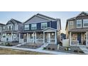 Attractive townhomes featuring stone and siding, a covered porch, and landscaped front yards at 7024 Kali Ct, Frederick, CO 80530