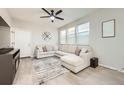 Bright living room with a ceiling fan, a large sectional couch, and ample natural light at 7024 Kali Ct, Frederick, CO 80530
