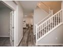 Inviting hallway featuring hardwood floors and a staircase with white banisters at 17600 Rose Heath Ln, Parker, CO 80134