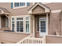 Close-up of a townhome entrance with a white door, bright windows, and a cozy, private deck area at 5555 E Briarwood Ave # 1404, Centennial, CO 80122