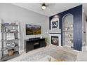 Living room with fireplace, TV, shelving, and cozy decor at 5555 E Briarwood Ave # 1404, Centennial, CO 80122
