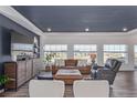 Bright living room featuring large windows, modern decor, and hardwood floors at 1079 Larkspur Dr, Erie, CO 80516