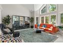 Bright living room features large windows, an orange sofa, and stylish decor at 15207 W Ellsworth Pl, Golden, CO 80401