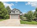 Beautiful exterior view of a two-story home with a well-manicured lawn, and a two car garage in a peaceful neighborhood at 15948 E 106Th Pl, Commerce City, CO 80022
