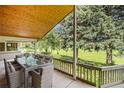 Inviting outdoor dining area on a covered patio, perfect for entertaining overlooking a green lawn at 78 Fairway Ln, Littleton, CO 80123