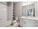 Bright bathroom featuring a tiled shower/tub, white vanity, and open shelving for plenty of storage space at 9287 Twenty Mile Rd # 108, Parker, CO 80134