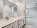 Primary bathroom with dual sinks, quartz counters, and walk-in shower, adjacent to a large bedroom at 9287 Twenty Mile Rd # 108, Parker, CO 80134