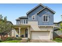 Charming home boasts a brick and siding exterior, two-car garage, and a cozy front porch at 859 Equinox Dr, Erie, CO 80516