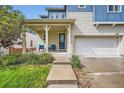 Inviting covered front porch with seating and a well-maintained walkway to the front door at 859 Equinox Dr, Erie, CO 80516