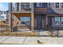 Townhome entrance with brick accents, storm door and decorative stone landscaping at 6840 Merseyside Ln, Castle Pines, CO 80108