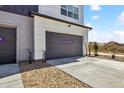 Attached two-car garage with gray door and concrete driveway, new construction at 6840 Merseyside Ln, Castle Pines, CO 80108