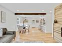 Well-lit living room featuring hardwood floors, dining area, and an open floorplan with modern accents at 2701 Barnhart St, Thornton, CO 80229