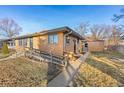 Side view of the house showcasing its brick facade and landscaping at 1338 Aspen Pl, Longmont, CO 80501