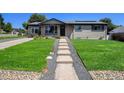Beautiful front yard with a stone pathway leading to a well-maintained home at 3999 W Chenango Ave, Littleton, CO 80123
